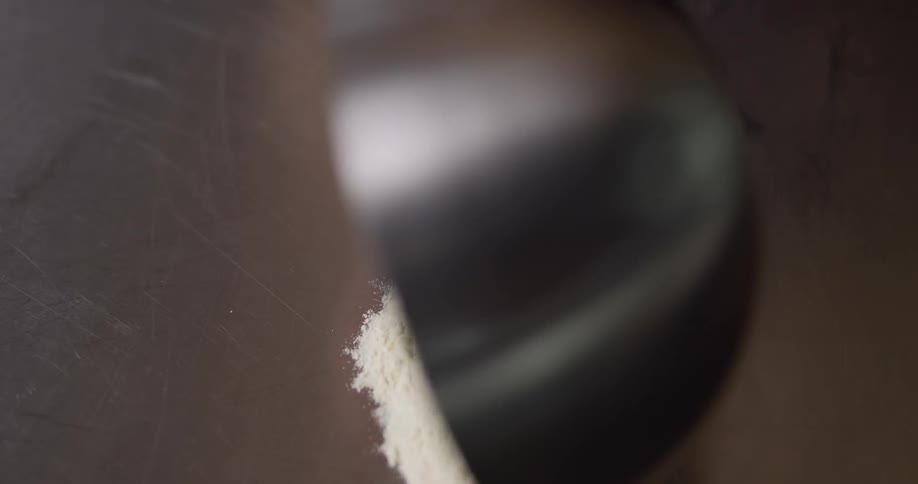 A person dumps flour out of a bowl