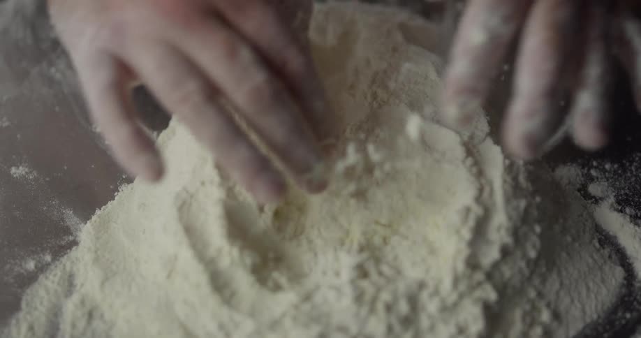 Mans hands scooping and mixing flour