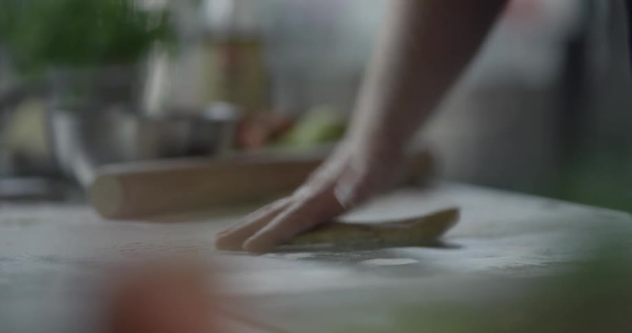 A man is cutting dough and flattening it