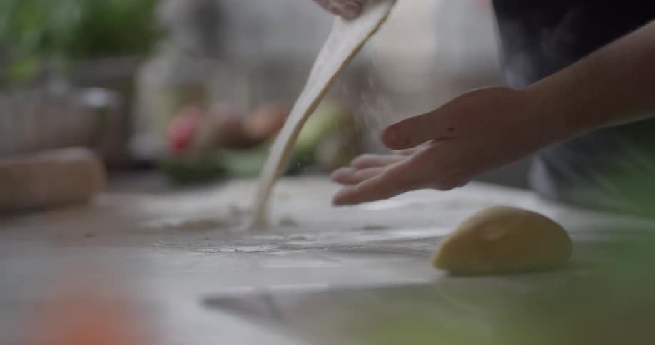 A chef scoops flour and prepares a dough