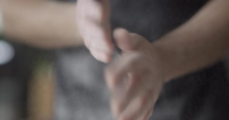 A person covering their hands in white powder