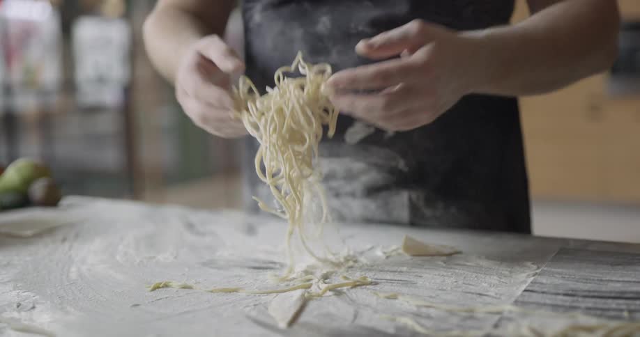 A chef tosses fresh pasta