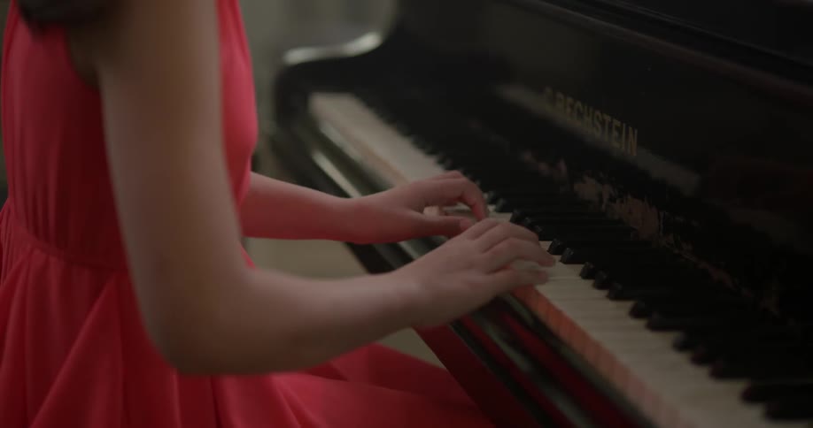 A girl sitting playing the piano