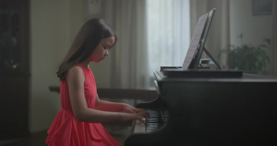 A girl plays a piano in a house