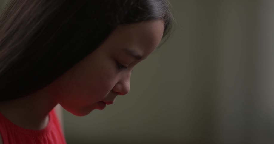 An Asian girl concentrates on what's in front of her