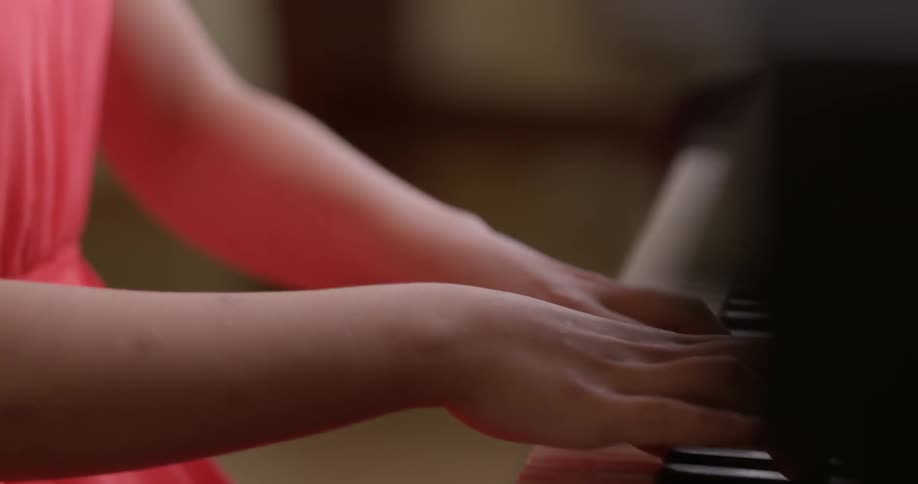 A young girl plays the piano