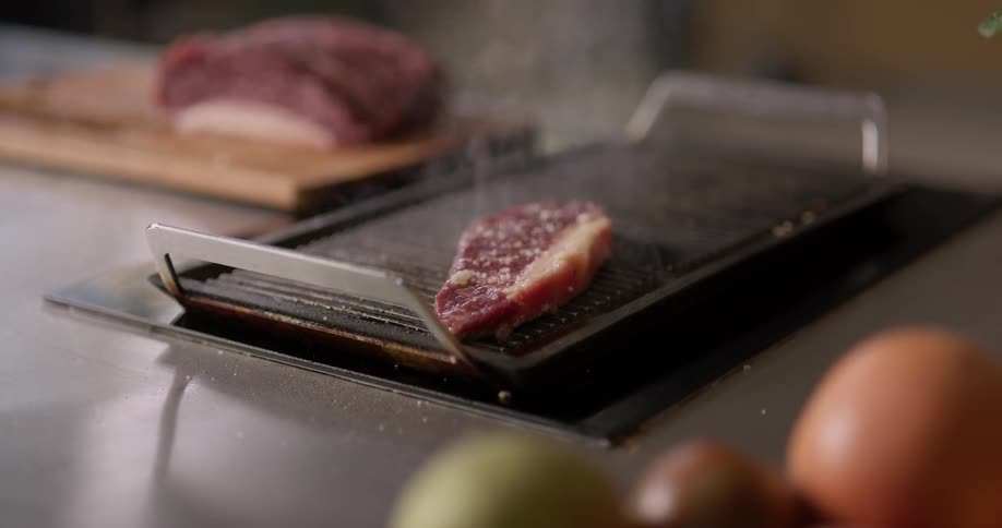 A steak sizzles on the grill