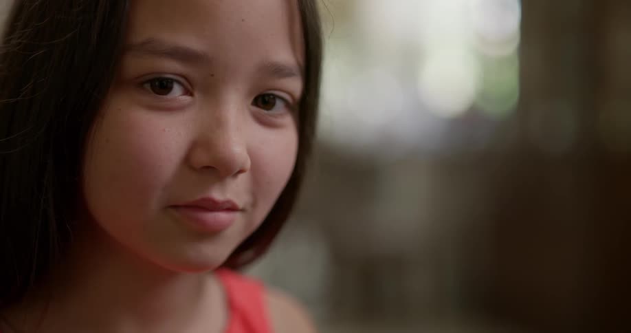 A young girl looks up with determination