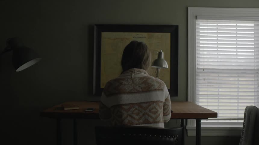 Woman in a sweater sits at a desk