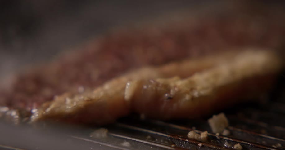 A piece of steak is flipped on a grill