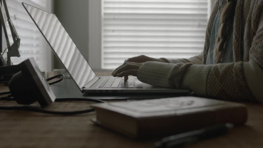 Person typing on their laptop while seated at their desk