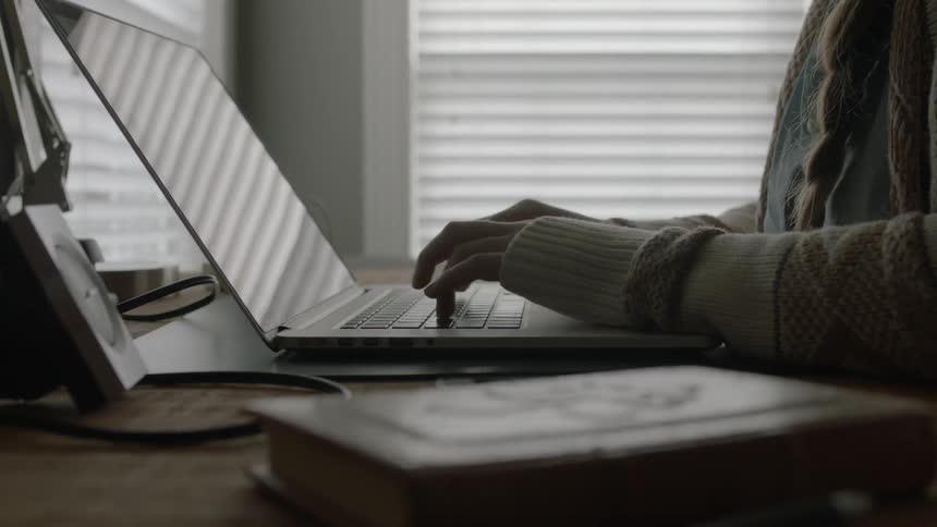 Woman begins to type on her laptop