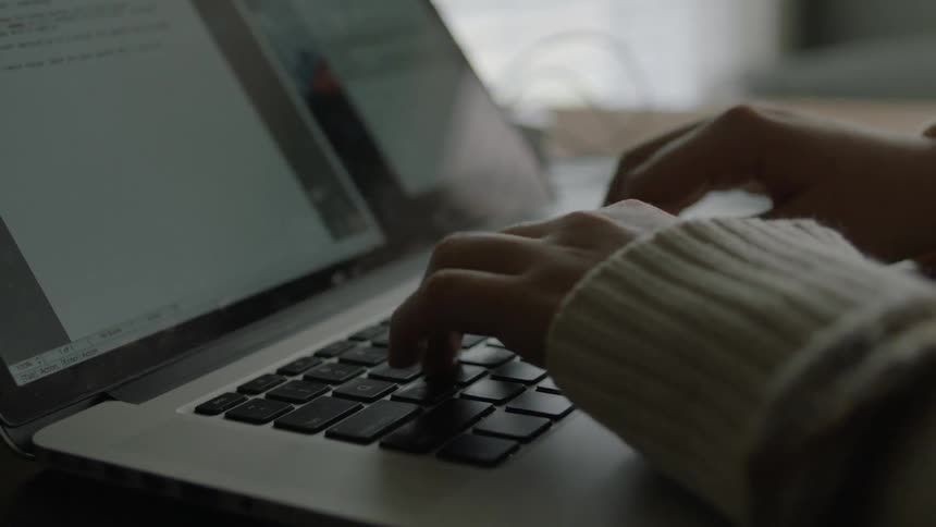 A person types on a laptop