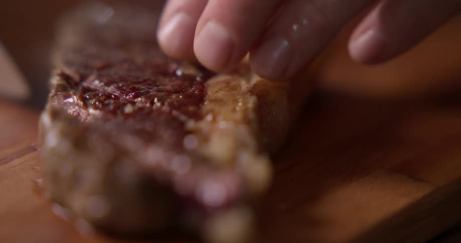 A knife slicing through a piece of steak