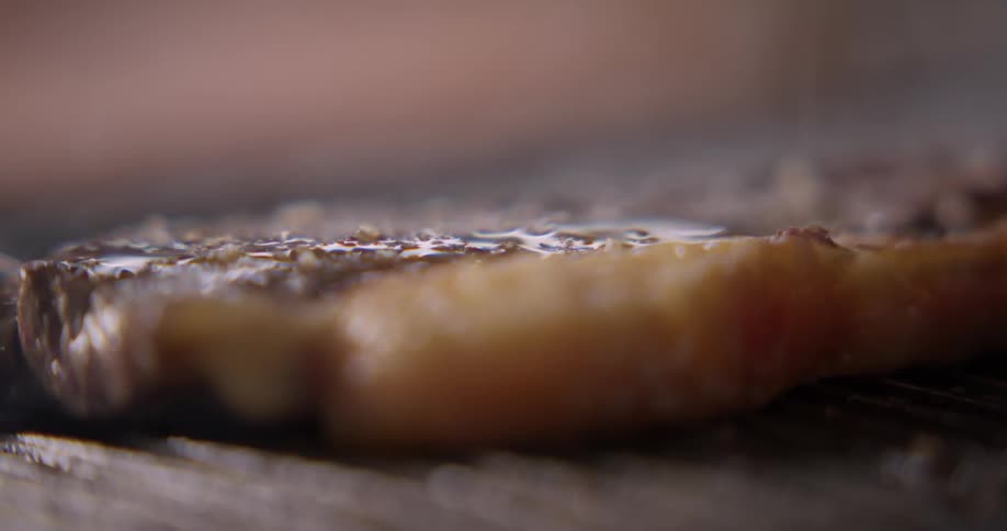 A piece of meat cooking on a grill