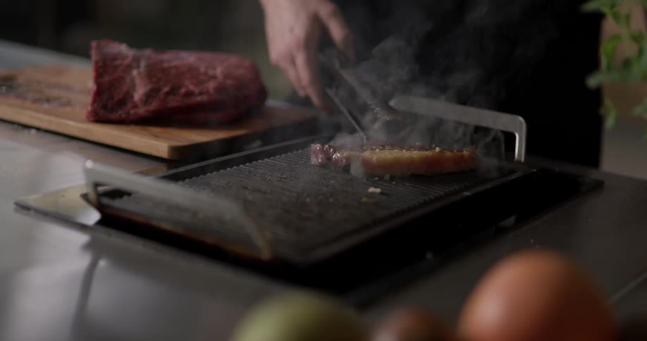 Steak being grilled on a stove top grill pan