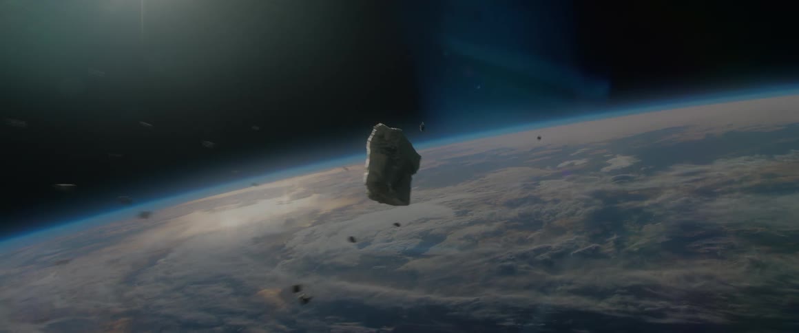 An asteroid flies through outer space headed to earth