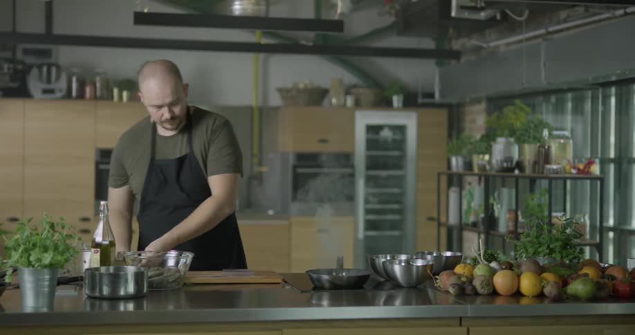 Man zesting a lemon over a frying pan