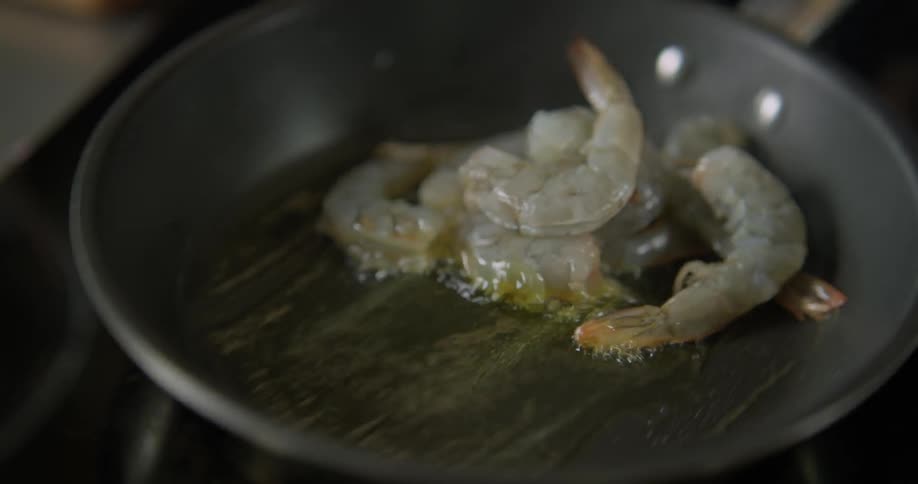 Shrimp sizzle in a pan of melted butter