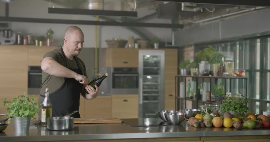 A man uses a knife to open a champagne bottle