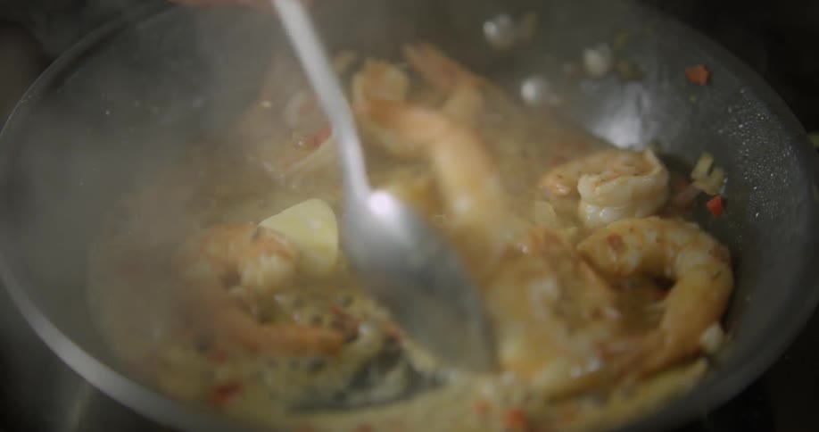 Shrimp is cooked in butter in a pan at high heat