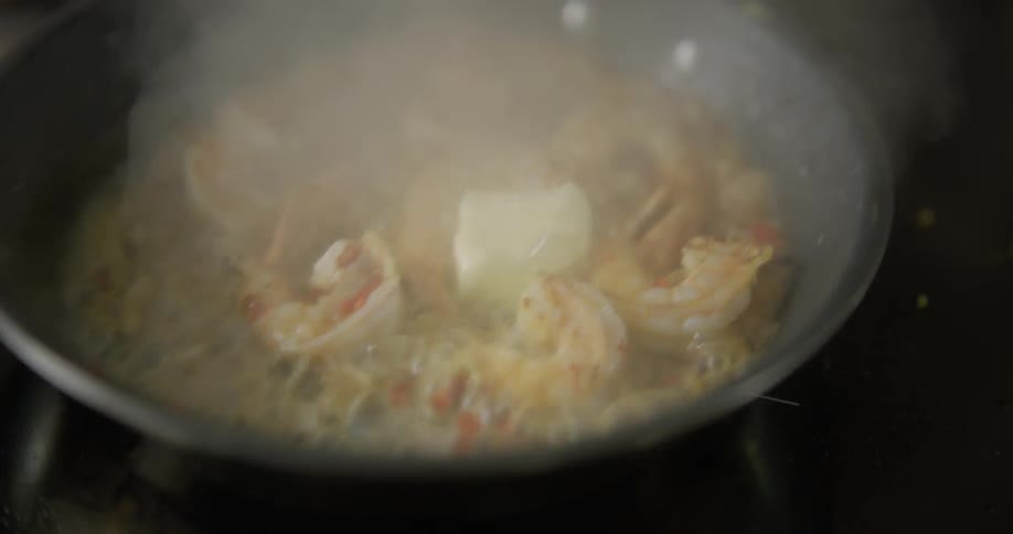 Butter is added to a pan of shrimp