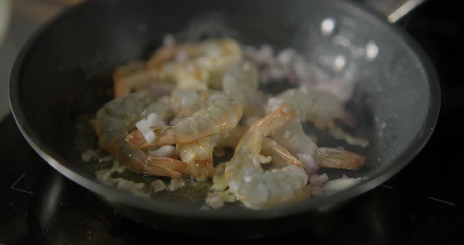 Close up of shrimp being sauteed in a frying pan