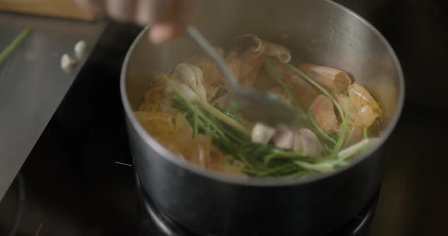 A person stirs a pot of food