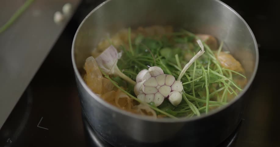 Items are being added to a pot on the stove