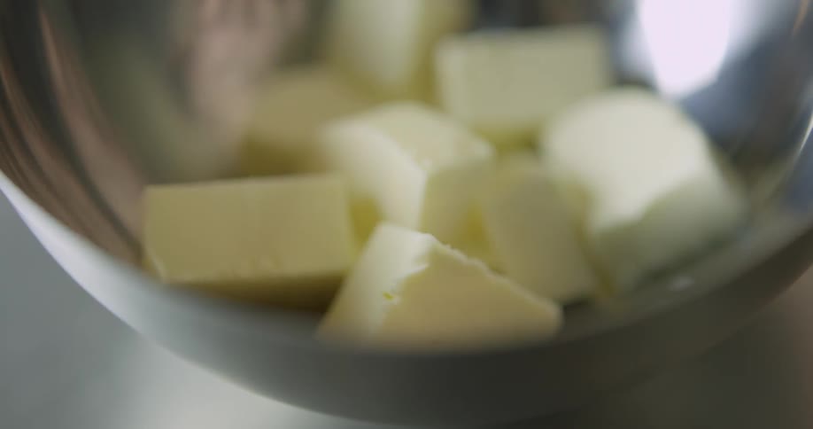 A person picks some butter out of bowl