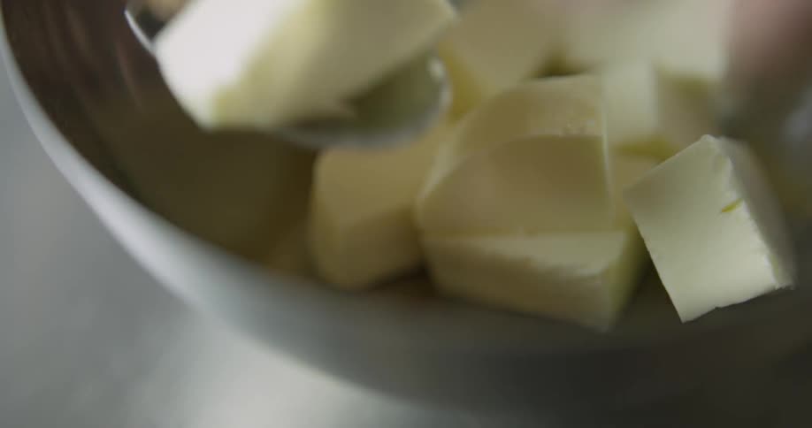 Small cubes of butter on a bowl being picked with a spoon