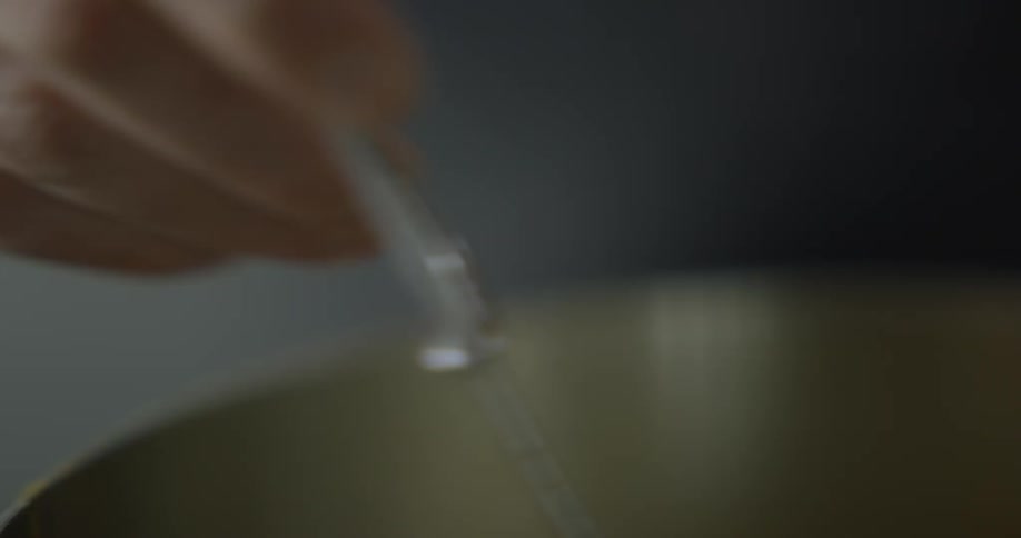 A person is stirring liquids together