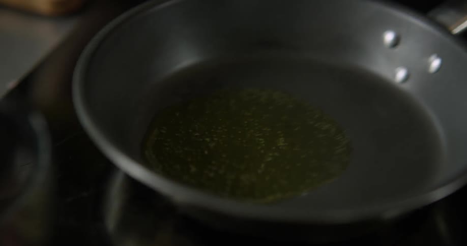 Yellow oil is poured into a pan and shaken around