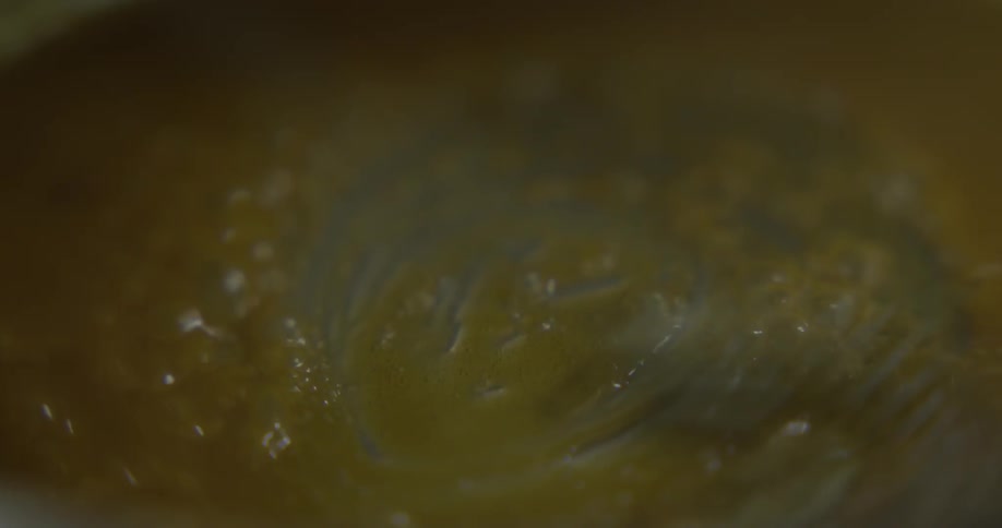 A person stirring butter in to a sauce