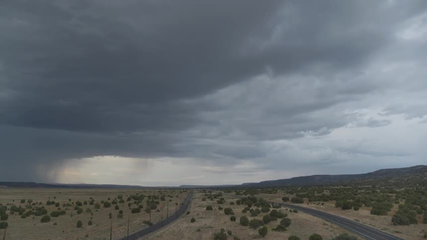 A storm rolls in across a desert highway