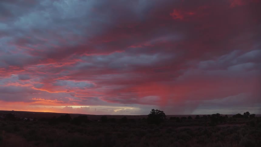 The camera looks out on a colorfully lit rain storm