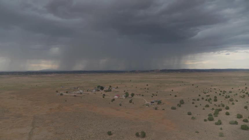 Aerial view of a field with a storm in the far off distance