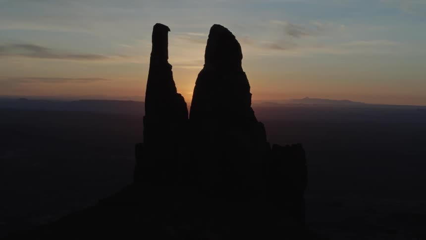 Two peaks with the sun and the sky in the background