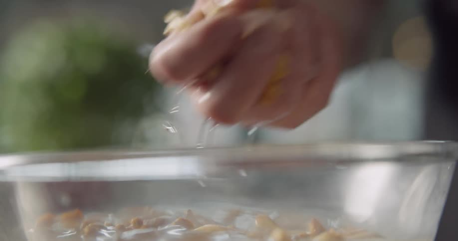 A man mixes food in a bowl of ice water and then removes it