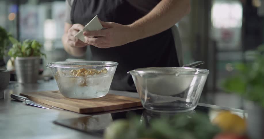 Cook washes mushrooms in a glass bowl