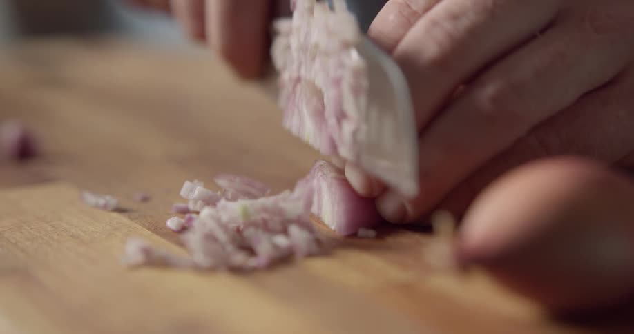 A person is cutting an onion indoors