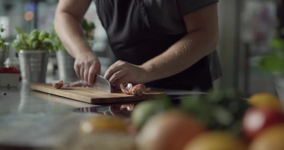 A man is cutting an onion indoors