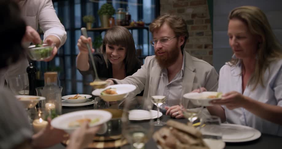 A family plating food at a dining table in the evening