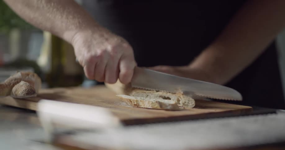 A person cuts bread on a cutting board