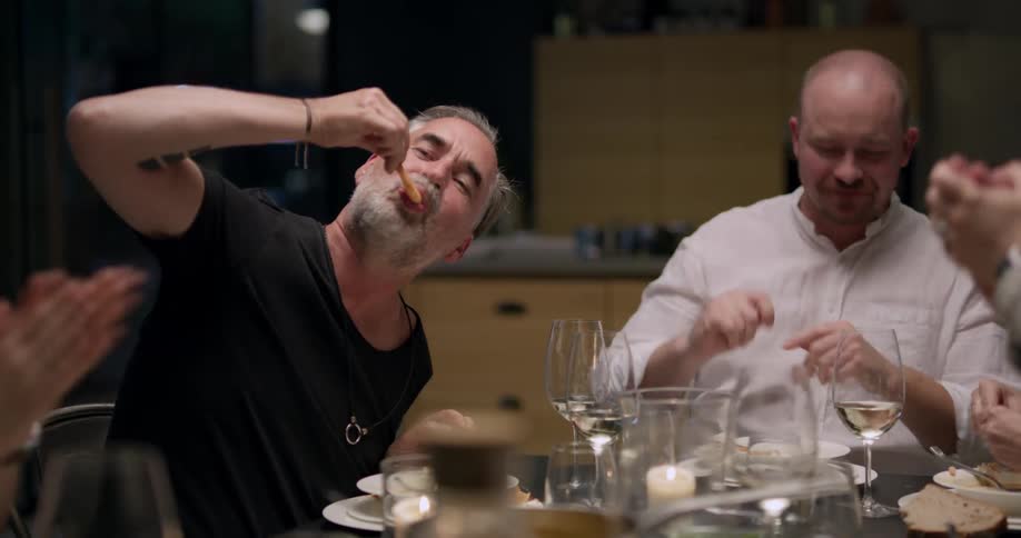 Friends having a dinner party eat and toast