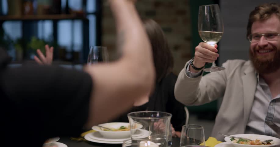 A group of friends make a toast at the dinner table