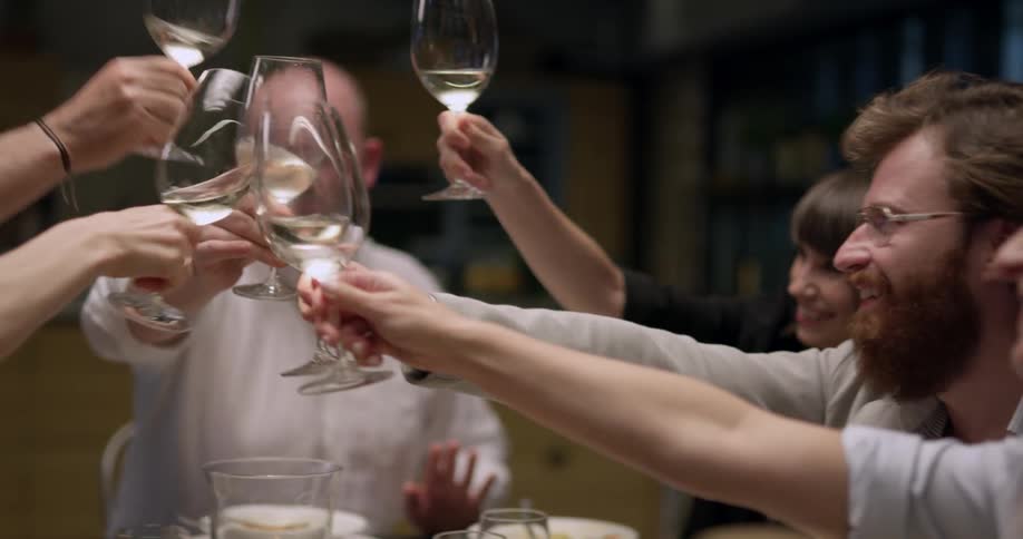 A man makes a toast at the head of the table