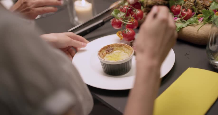 People at a table eating tomatoes and beef