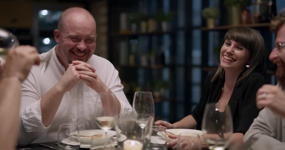 People sit down and have dinner while laughing in the night