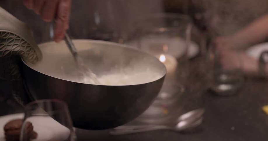 Smoke coming out of a bowl while someone stirs